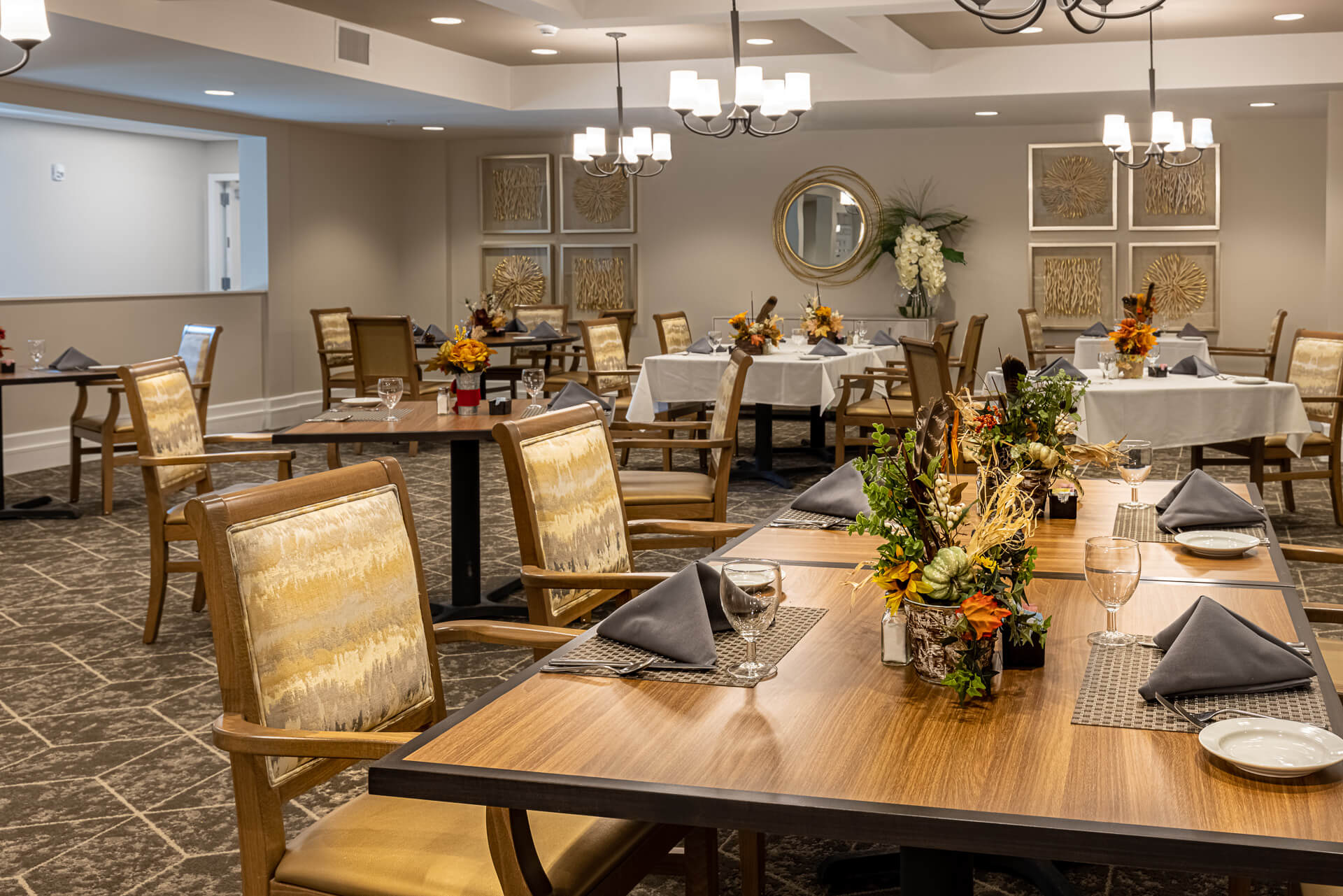 Ryan_BellevuePlace_Nashville_DavidKeith-345-HDR-Edit-2 A large dining room with tables and chairs. Flowers are a centerpiece on every table and each place is set