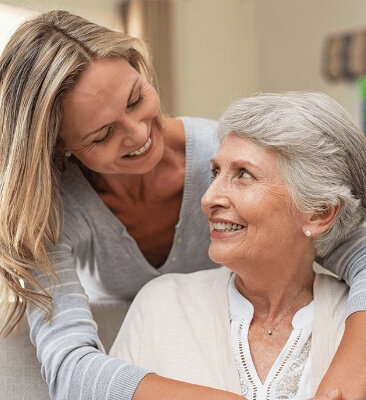 Senior woman and her happy daughter embrace in a hug