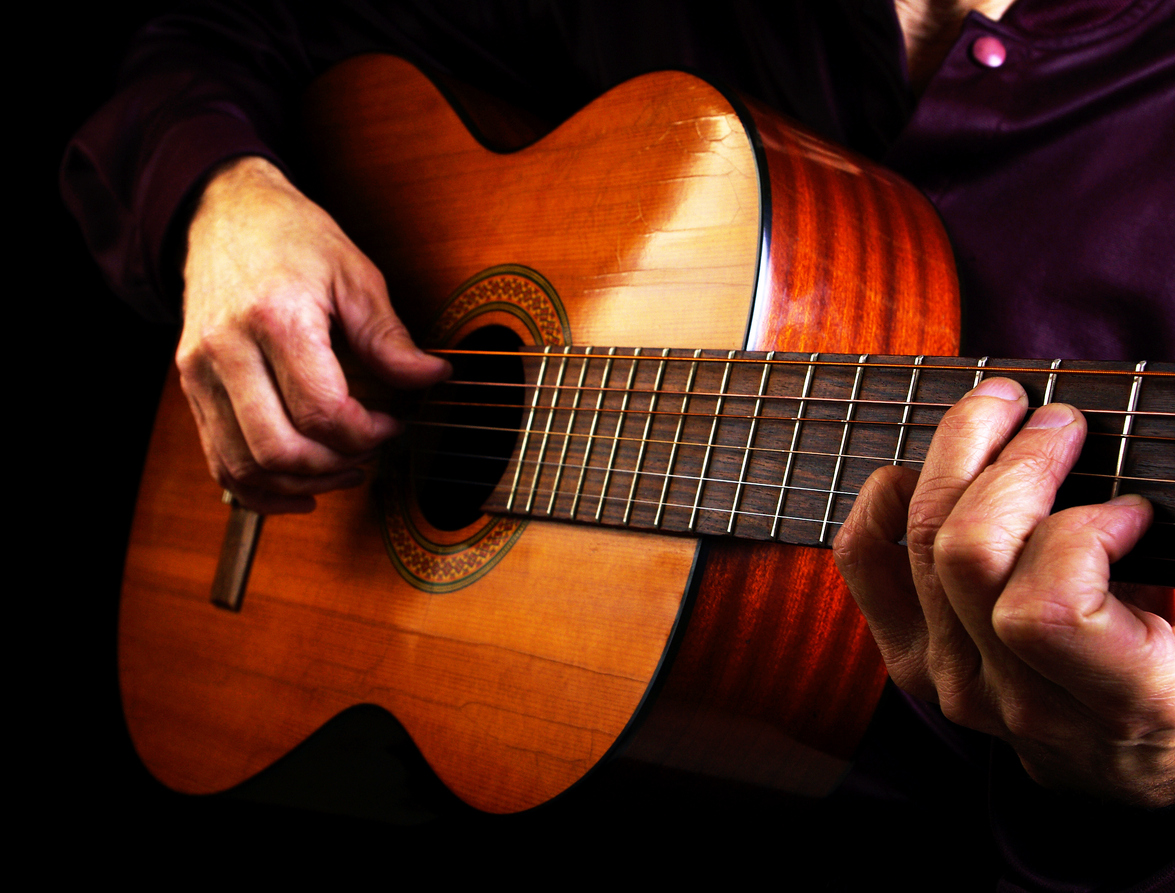 Playing an Acoustic Guitar. Closeup.